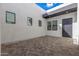 Exterior courtyard with a tiled floor, white stucco walls, and ample natural light from surrounding windows at 10302 E Utah Ave, Mesa, AZ 85212