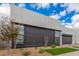 Contemporary home showcasing a gray design, expansive windows, and xeriscaped landscaping for low-maintenance appeal at 10302 E Utah Ave, Mesa, AZ 85212