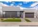 Striking modern home with a gray facade, large windows, and minimalist xeriscaped front yard at 10302 E Utah Ave, Mesa, AZ 85212