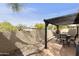 Serene back patio with pergola and patio seating with a desert landscape beyond the backyard wall at 10812 N 117Th Pl, Scottsdale, AZ 85259