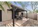 Inviting back patio with a dark pergola and space for seating that extends to a private gravel yard at 10812 N 117Th Pl, Scottsdale, AZ 85259