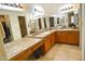 Bright bathroom featuring double sinks, a large mirror, and wood cabinets offering ample storage space at 10812 N 117Th Pl, Scottsdale, AZ 85259
