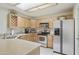 Galley kitchen features light countertops, dual basin sink, stainless appliances, and light colored wood cabinets at 10812 N 117Th Pl, Scottsdale, AZ 85259