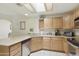 Cozy kitchen features light wood cabinetry, light countertops, a dual basin sink, and stainless steel appliances at 10812 N 117Th Pl, Scottsdale, AZ 85259