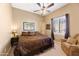 Comfortable bedroom with a ceiling fan, a window with blinds, and a cozy armchair at 12706 E Desert Cove Ave, Scottsdale, AZ 85259