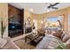 Inviting living room with fireplace, ceiling fan, and views of the outdoor space at 12706 E Desert Cove Ave, Scottsdale, AZ 85259