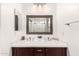 Bright bathroom featuring a double sink vanity with dark wood cabinets and modern fixtures at 13153 W Clarendon Ave, Litchfield Park, AZ 85340