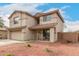 Two-story home with front porch, two-car garage, and desert-style landscaping at 13153 W Clarendon Ave, Litchfield Park, AZ 85340