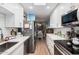 Galley kitchen showcasing stainless steel appliances, white cabinetry, marble countertops, and an open layout to the dining area at 14300 W Bell Rd # 117, Surprise, AZ 85374