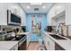 Bright kitchen featuring white cabinetry, marble countertops and backsplash, stainless steel appliances, and vibrant blue accent wall at 14300 W Bell Rd # 117, Surprise, AZ 85374