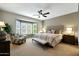 Serene primary bedroom with a bay window, ceiling fan, and a king-sized bed at 15501 W Las Verdes Way, Surprise, AZ 85374