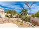 Desert backyard featuring a patio with a seating area, windmill, and mature landscaping at 15803 E Tumbleweed Dr, Fountain Hills, AZ 85268