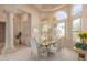 Formal dining room featuring elegant chandelier, arched windows, a glass table and views of the front yard at 15803 E Tumbleweed Dr, Fountain Hills, AZ 85268