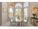 Dining room filled with natural light through large arched windows, featuring a glass table and elegant decor at 15803 E Tumbleweed Dr, Fountain Hills, AZ 85268