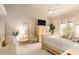 Bright main bedroom with a ceiling fan, a TV atop a cabinet, a decorative tree, and a seating area at 15803 E Tumbleweed Dr, Fountain Hills, AZ 85268