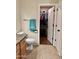 Bathroom with a door open to a closet with shelving and lots of clothing at 16243 N 27Th St, Phoenix, AZ 85032