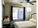 Bedroom featuring a ceiling fan, bed, and a window with dark curtains at 16243 N 27Th St, Phoenix, AZ 85032