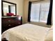 Bedroom featuring a bed, window, dark curtains and a dresser with a flower arrangement at 16243 N 27Th St, Phoenix, AZ 85032