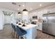 Contemporary kitchen with a large island, stainless steel appliances, and elegant pendant lighting at 17162 W Corrine Dr, Surprise, AZ 85388