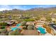 Aerial view showcasing a lavish community pool area with multiple pools, shaded cabanas, and well-manicured landscaping and mountain views at 17505 N 96Th Way, Scottsdale, AZ 85255