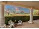 Relaxing covered patio featuring white wicker furniture and scenic golf course views, perfect for enjoying the outdoors at 18833 E Latigo Ln, Rio Verde, AZ 85263