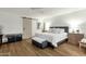 Bright bedroom with a queen bed, ceiling fan, barn door, and wood-look flooring at 18833 E Latigo Ln, Rio Verde, AZ 85263