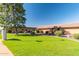 Exterior shot of condo featuring vibrant green lawn, mature tree, and well-maintained surroundings at 20421 N 3Rd Dr # 2, Phoenix, AZ 85027