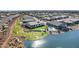 Aerial view showcasing a neighborhood with lush green grass, a lake and a swimming pool at 20745 N Verbena Ln, Maricopa, AZ 85138