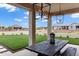 Relaxing outdoor dining area with pergola, lush lawn and beautiful desert landscaping at 20745 N Verbena Ln, Maricopa, AZ 85138