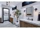 Well-lit bathroom with dual vanities, modern sinks, and decorative lighting fixtures at 20745 N Verbena Ln, Maricopa, AZ 85138