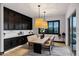 Open dining area with modern lighting, wooden table, and upholstered chairs at 20745 N Verbena Ln, Maricopa, AZ 85138