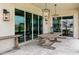 Inviting covered patio with travertine flooring, outdoor lighting, and comfortable dining area at 20745 N Verbena Ln, Maricopa, AZ 85138