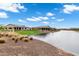 Beautiful water view of community with lush green lawns and desert landscaping on a bright, sunny day at 20745 N Verbena Ln, Maricopa, AZ 85138