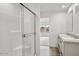 Bright bathroom with a glass-enclosed shower, double sinks, modern vanity, and wood-look flooring at 222 S Oak Rd, Maricopa, AZ 85139