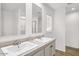 Modern bathroom featuring double sinks, stone countertops, wood-look flooring, and bright natural light at 222 S Oak Rd, Maricopa, AZ 85139