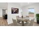 Charming dining room with a round table set for four, large windows, and modern art at 222 S Oak Rd, Maricopa, AZ 85139