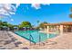 A community pool featuring lounge chairs, tables with umbrellas, clear blue water, and a shaded seating area for residents to enjoy at 2284 Leisure World --, Mesa, AZ 85206