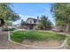 Grassy backyard with shaded patio, pool, mature trees and a view of the home's exterior at 2501 E Los Alamos St, Gilbert, AZ 85295