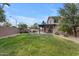 Home featuring backyard with grass, rock waterfall pool, and covered patio with ceiling fan at 2501 E Los Alamos St, Gilbert, AZ 85295