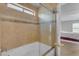 Bathtub with decorative tile surround and glass shower door at 2501 E Los Alamos St, Gilbert, AZ 85295