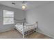 Cozy bedroom with a metal frame bed, ceiling fan, and window with natural light at 2501 E Los Alamos St, Gilbert, AZ 85295