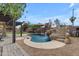 Backyard oasis featuring a pool with rock waterfall and lush landscaping at 2501 E Los Alamos St, Gilbert, AZ 85295