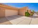 Side angle view of the exterior of a home featuring a two car garage and desert landscaping at 2565 S Signal Butte Rd # 8, Mesa, AZ 85209