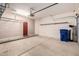 Clean garage space with shelving, a painted red entry door, and sealed concrete floors at 2565 S Signal Butte Rd # 8, Mesa, AZ 85209