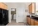 Kitchen featuring wooden cabinetry, black appliances and doorway to laundry room at 2565 S Signal Butte Rd # 8, Mesa, AZ 85209