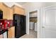 Kitchen with warm cabinetry, black appliances, and a convenient laundry area at 2565 S Signal Butte Rd # 8, Mesa, AZ 85209