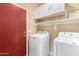 Well-lit laundry room featuring a washer and dryer with white shelving and cabinets above at 2565 S Signal Butte Rd # 8, Mesa, AZ 85209