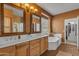 Bathroom featuring double sinks with framed mirrors, soaking tub, tiled floors, and warm paint at 2688 S Racine Ct, Gilbert, AZ 85295