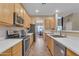 Open kitchen with quartz countertops, stainless steel appliances, and a view to the dining area at 2688 S Racine Ct, Gilbert, AZ 85295