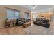 Inviting living room featuring leather sofas, neutral walls, and an open layout to dining area at 2688 S Racine Ct, Gilbert, AZ 85295